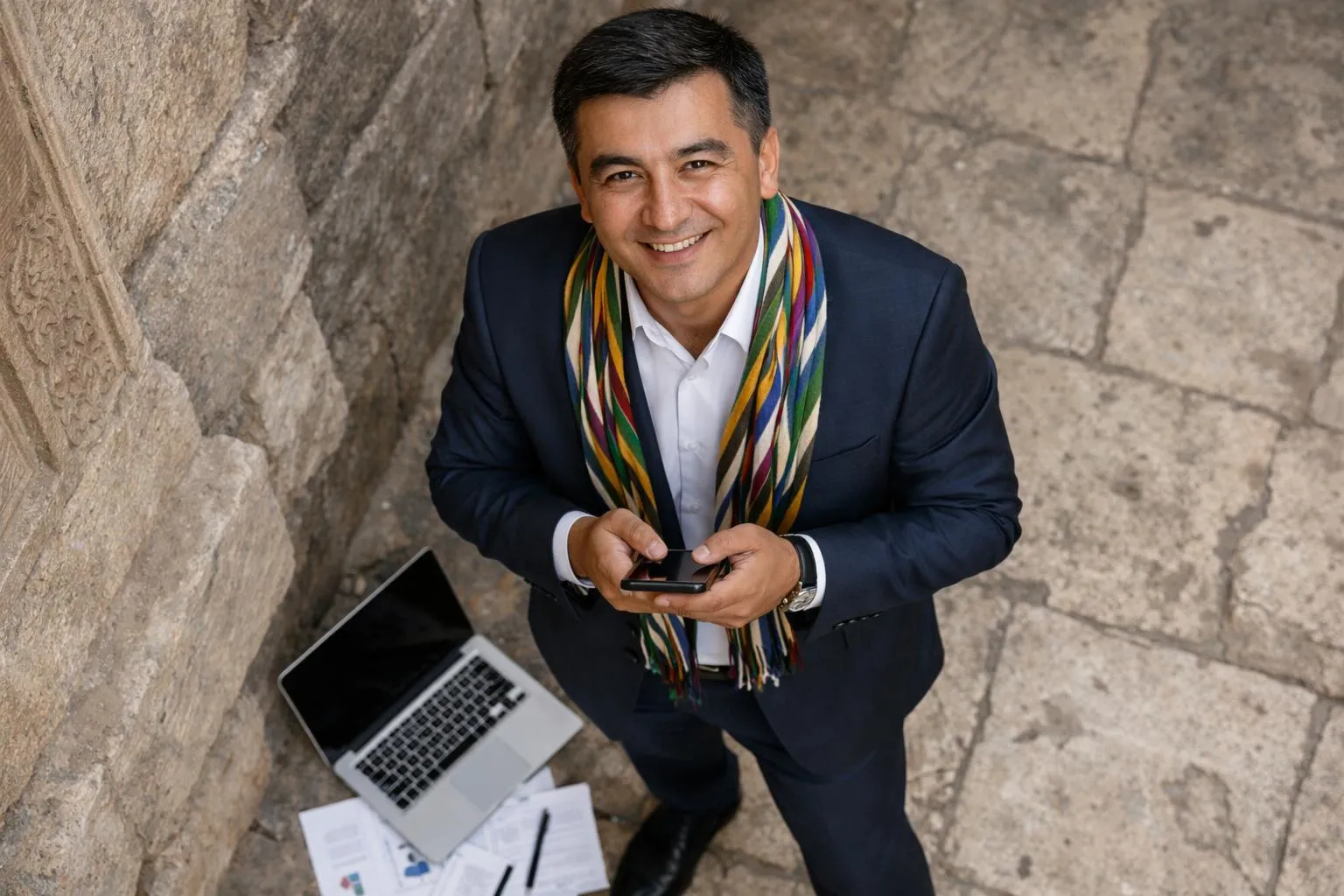 "Un homme d'affaires en Ouzbékistan utilise son smartphone dans un cadre historique"