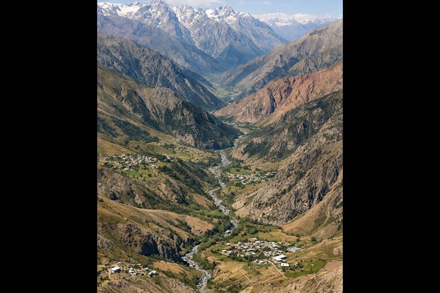 Paysage montagneux du sud du Kirghizistan avec des villages isolés et des vallées à l'infrastructure minimale, suggérant une présence étatique limitée et une fragmentation géographique dans les régions reculées.